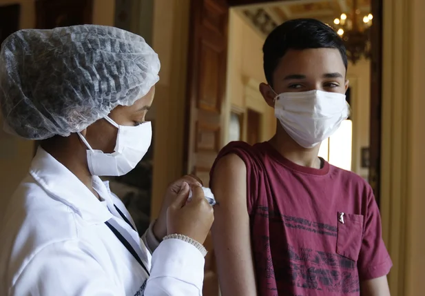 Adolescente recebendo a vacina contra a covid-19