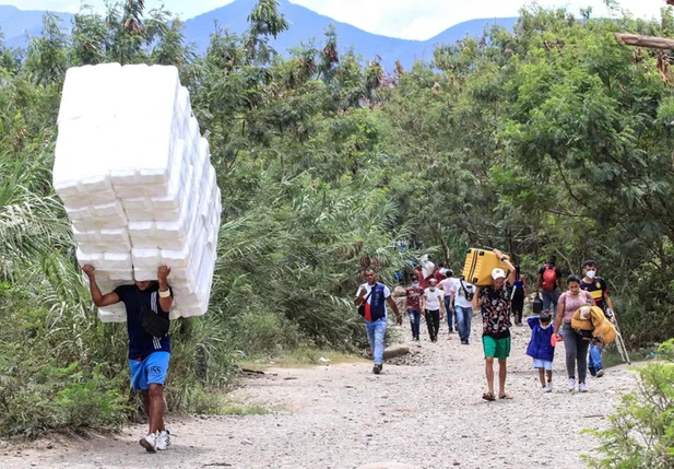 Dezenas de pessoas atravessando a fronteira da Venezuela para a Colômbia.