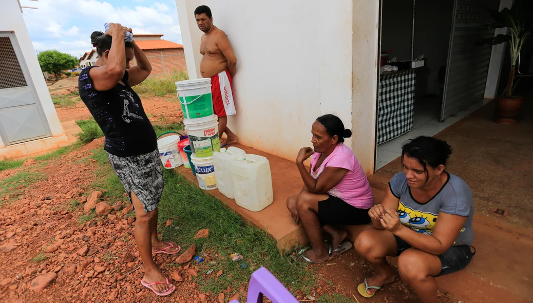 Moradores fazem fila para pegar água em torneira