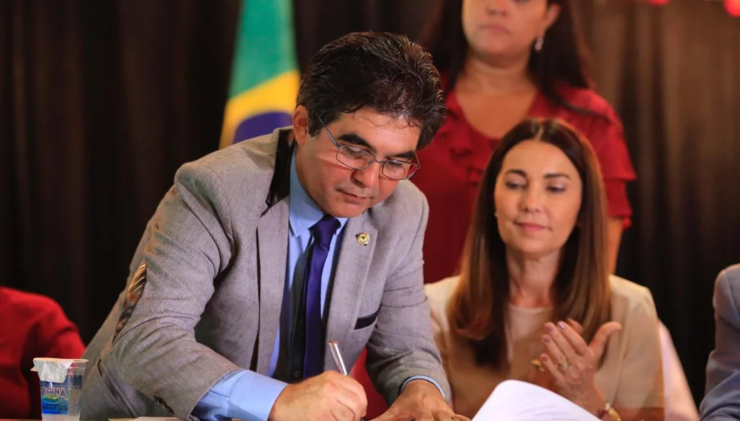 Secretario Francisco Limma assinando certificados de imóveis quitados 