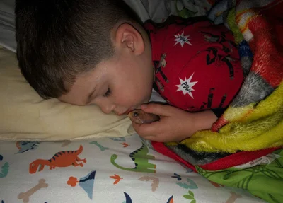 O menino amava tanto seu peixe que resolveu tirá-lo do aquário para que pudessem dormir abraçados