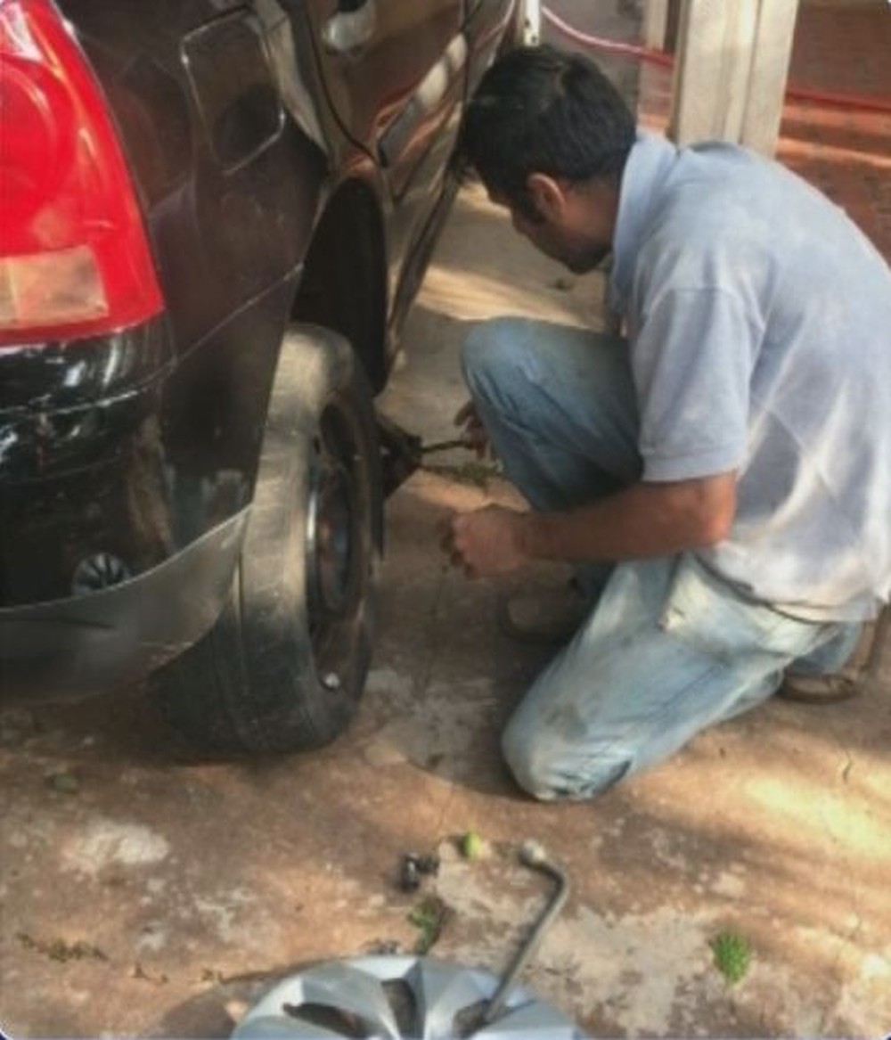 Suspeito do crime trocando o pneu do carro da vítima