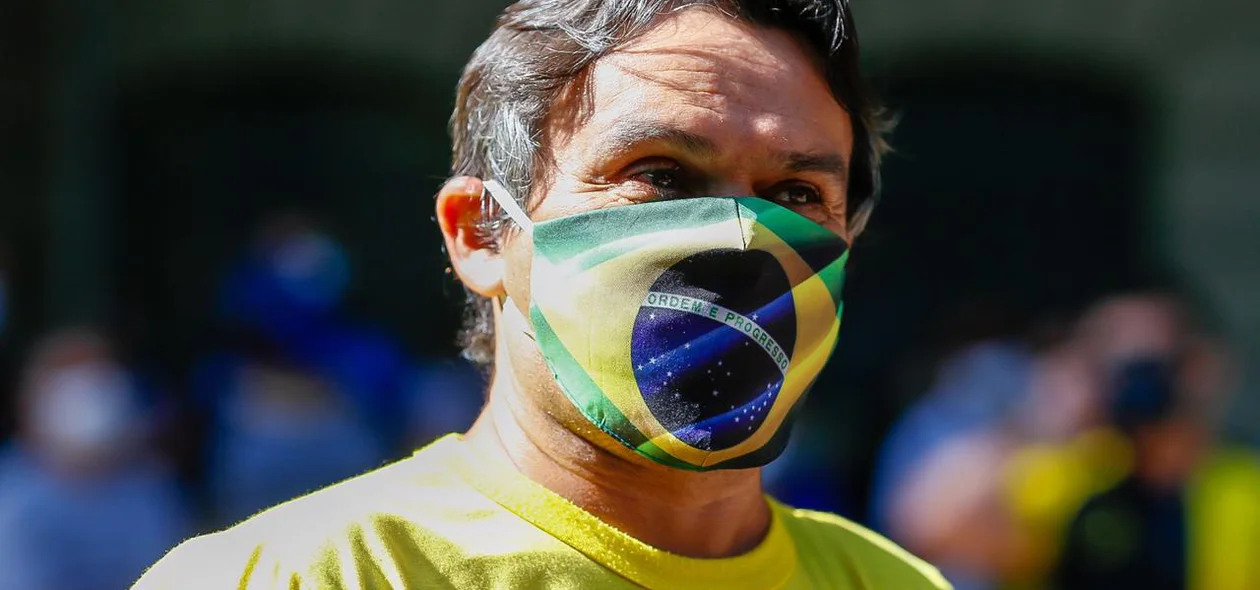 Manifestante com máscara da bandeira do Brasil