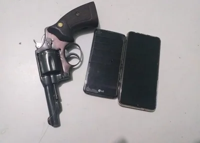 Arma de fogo e celulares apreendidos com o suspeito